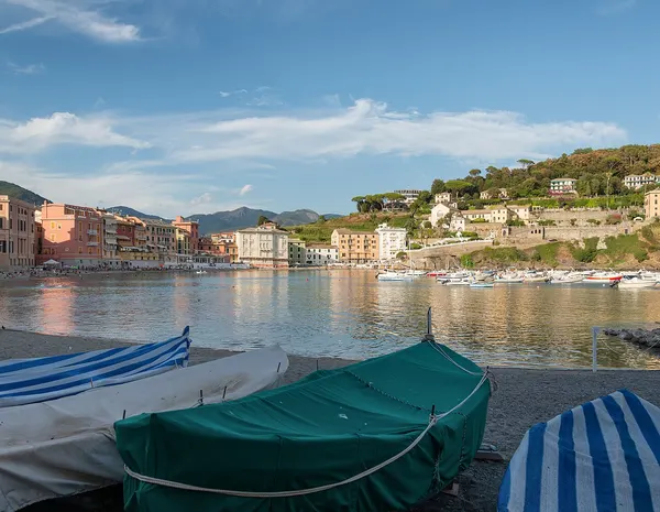 Baia del Silenzio a Sestri Levante, con barche in primo piano e case affacciate sulla spiaggia.