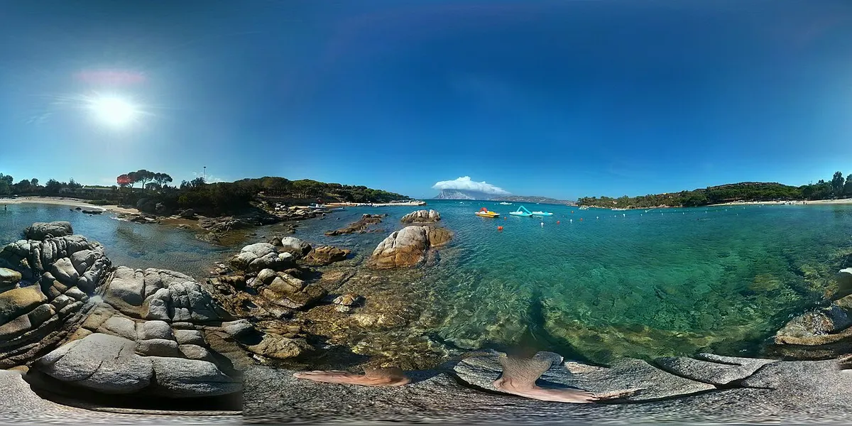 Panorama della riva di Cala Suaraccia con rocce, mare e spiaggia.