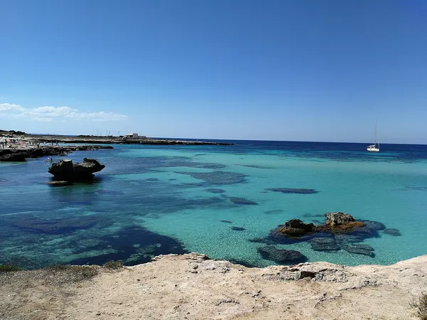 Acqua e scogli piatti presso Lido Burrone a Favignana; il margine roccioso non mostra tutta la spiaggia sabbiosa.