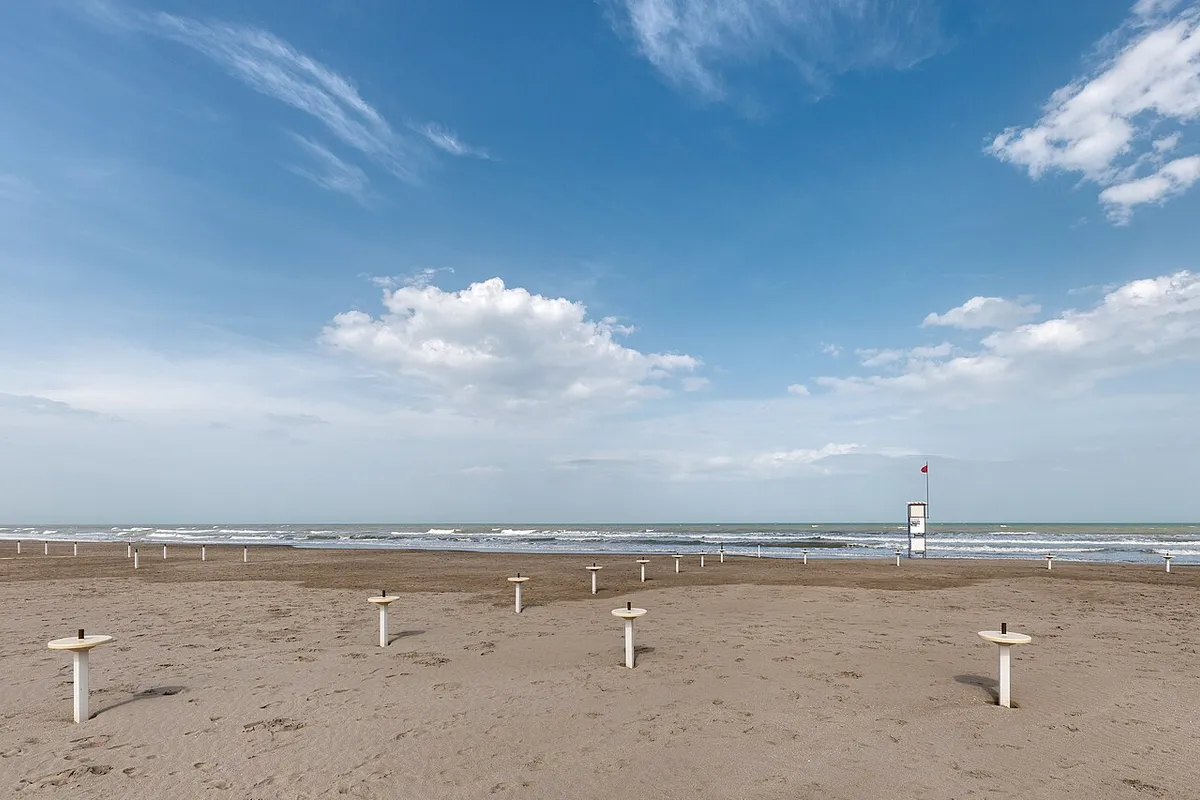 Litorale di Milano Marittima in aprile, con arenile sabbioso, mare e una torretta sulla riva.