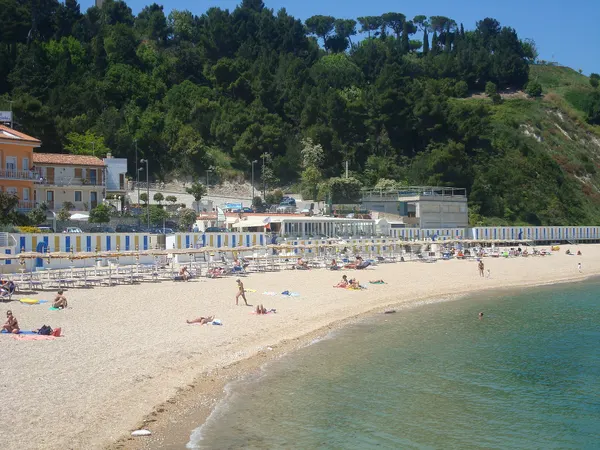 La Spiaggiola di Numana, con riva curva, strutture balneari e versante alberato nel 2008.