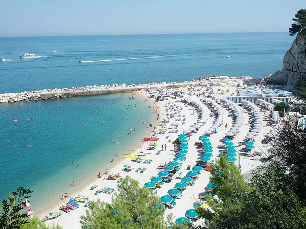 Vista dall’alto della spiaggia Urbani, con il molo e gli ombrelloni.
